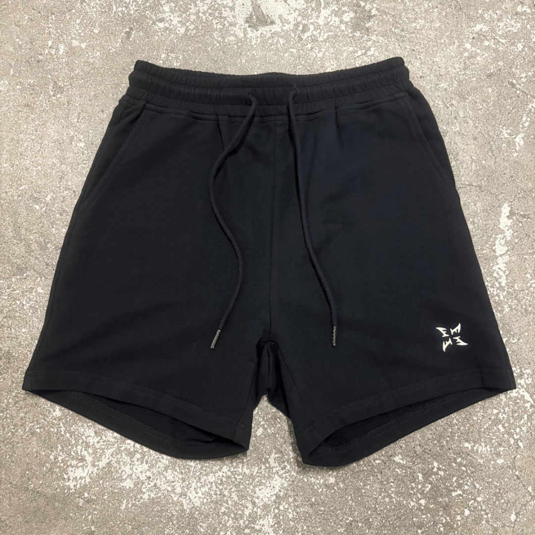 Black shorts with a small logo on a gray surface